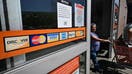 A display of credit cards accepted for use is seen on a door as a shopper steps out of a store on September 12, 2023 in Monterey Park, California. Credit card debt from US consumers is rising by billions of dollars amid higher inflation and interest rates, topping $1 trillion for the first time in history, according to the Federal Reserve Bank of New York. 