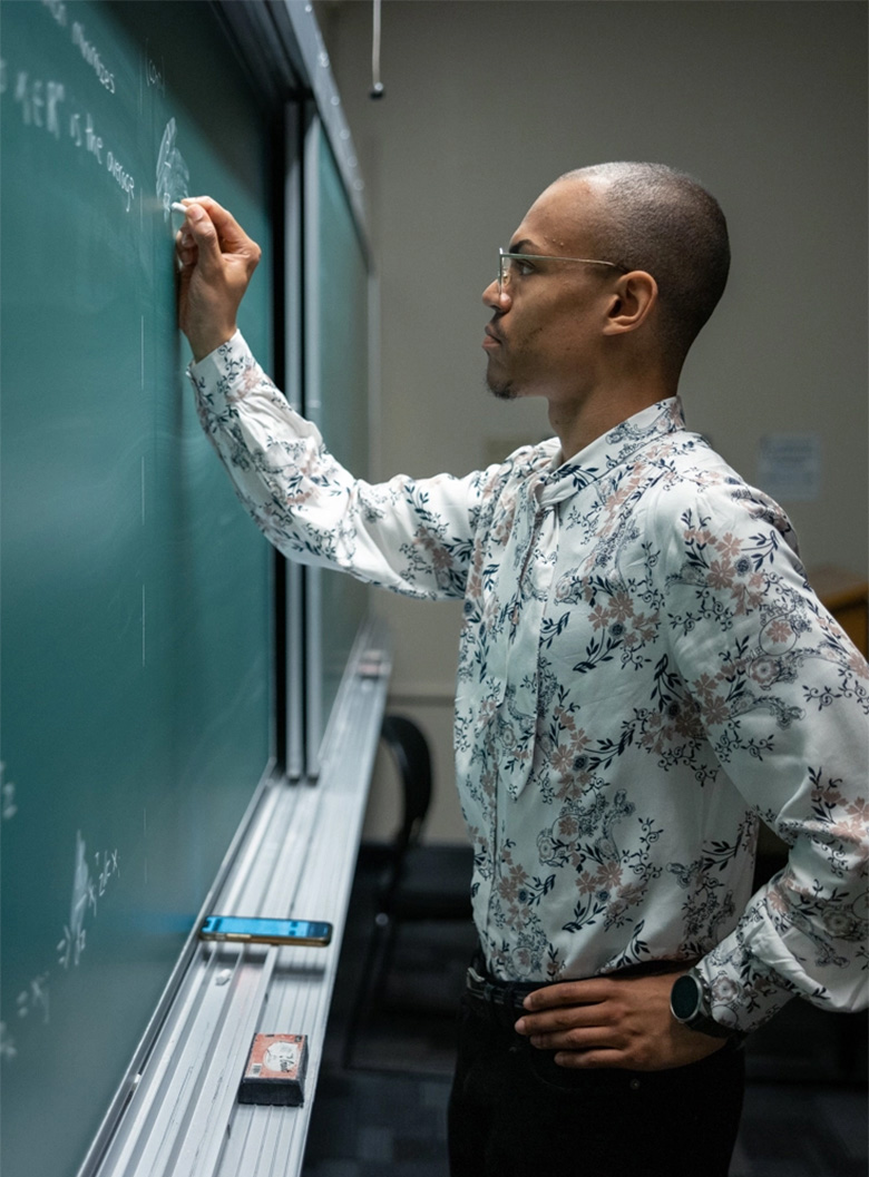 Professor writing on chalkboard