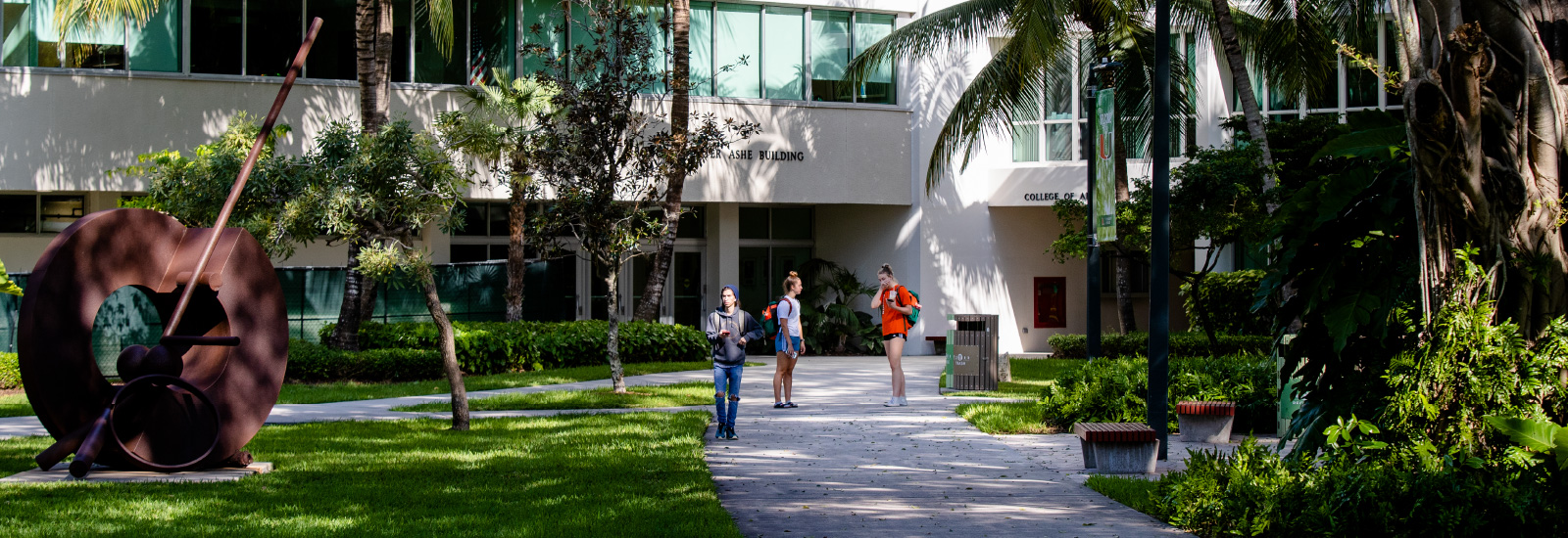 Students speaking in front of the Ashe Building walkway.