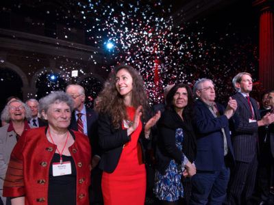 People smiling and celebrating with festive backdrop