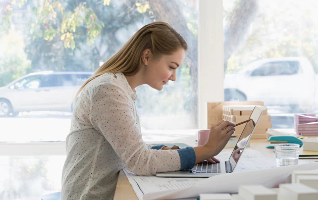 Woman at home using a computer at desk.