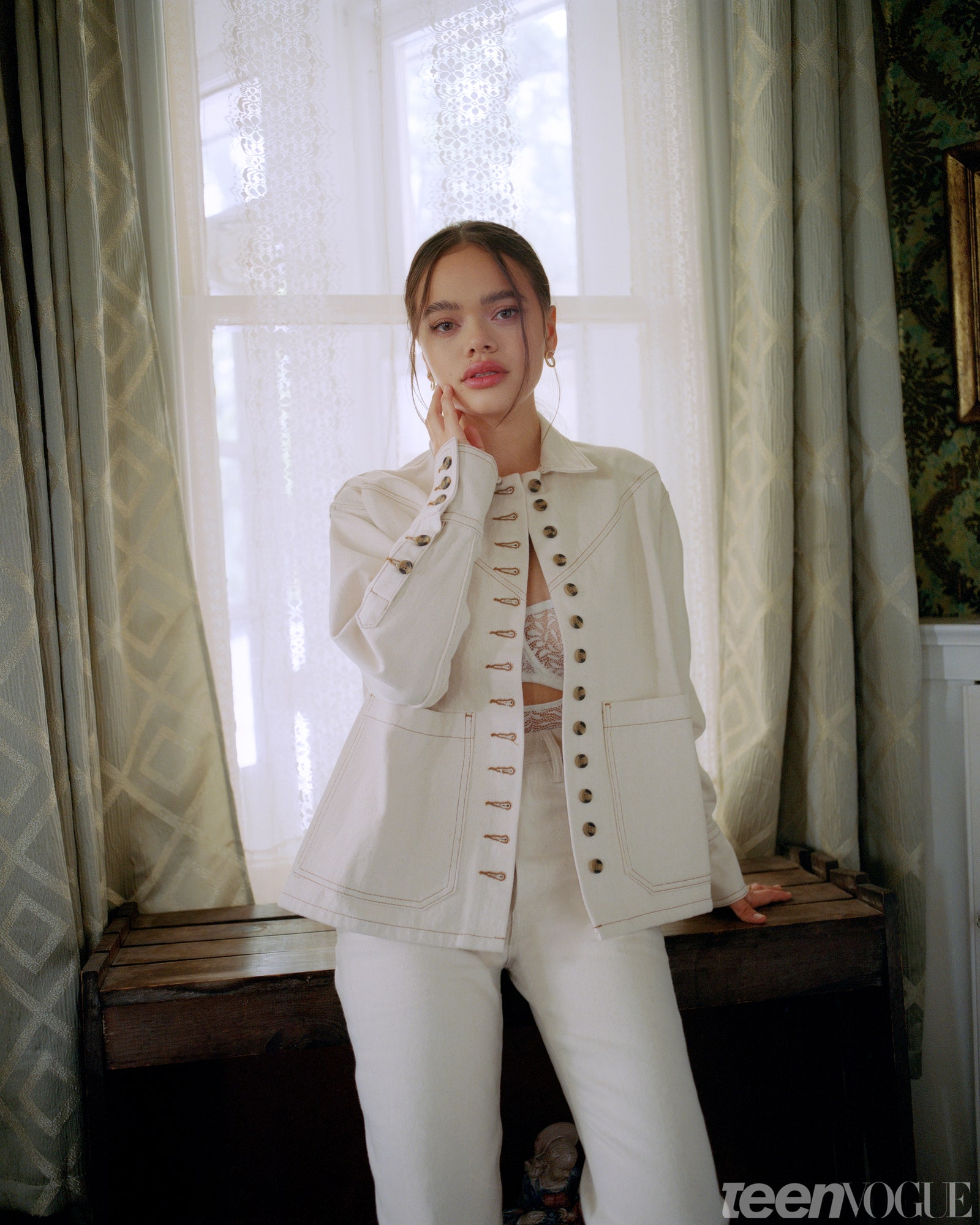 Malia standing artfully in a room with daylight behind her in the window