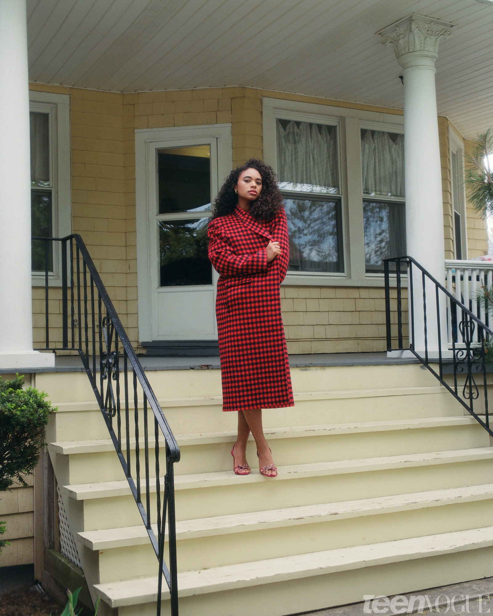 Chandler wrapped in long trench coat standing on steps