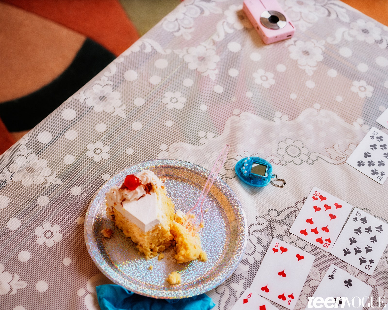 A partially eaten slice of cake with playing cards on the table