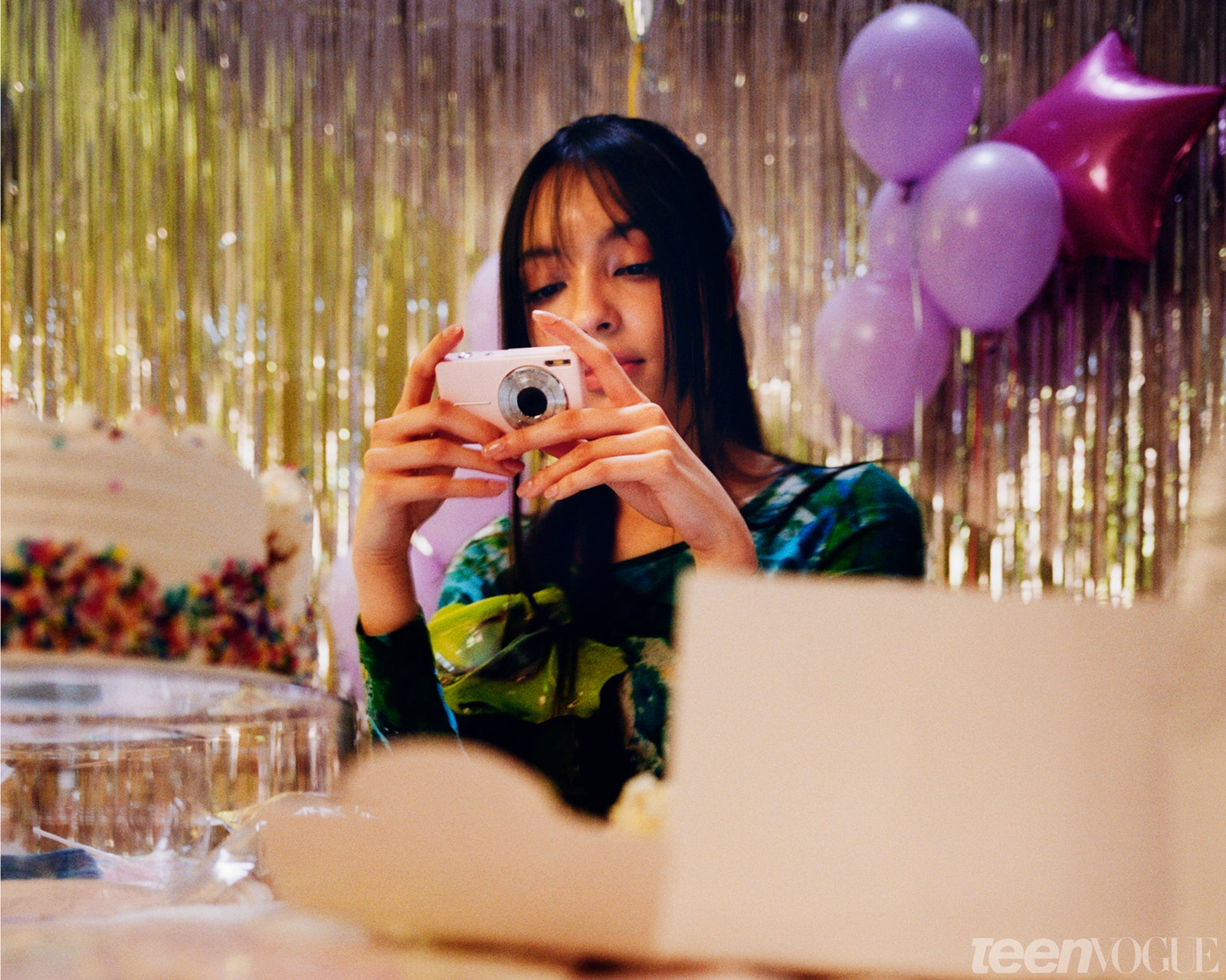 Camila looks at a digital camera screen at a party