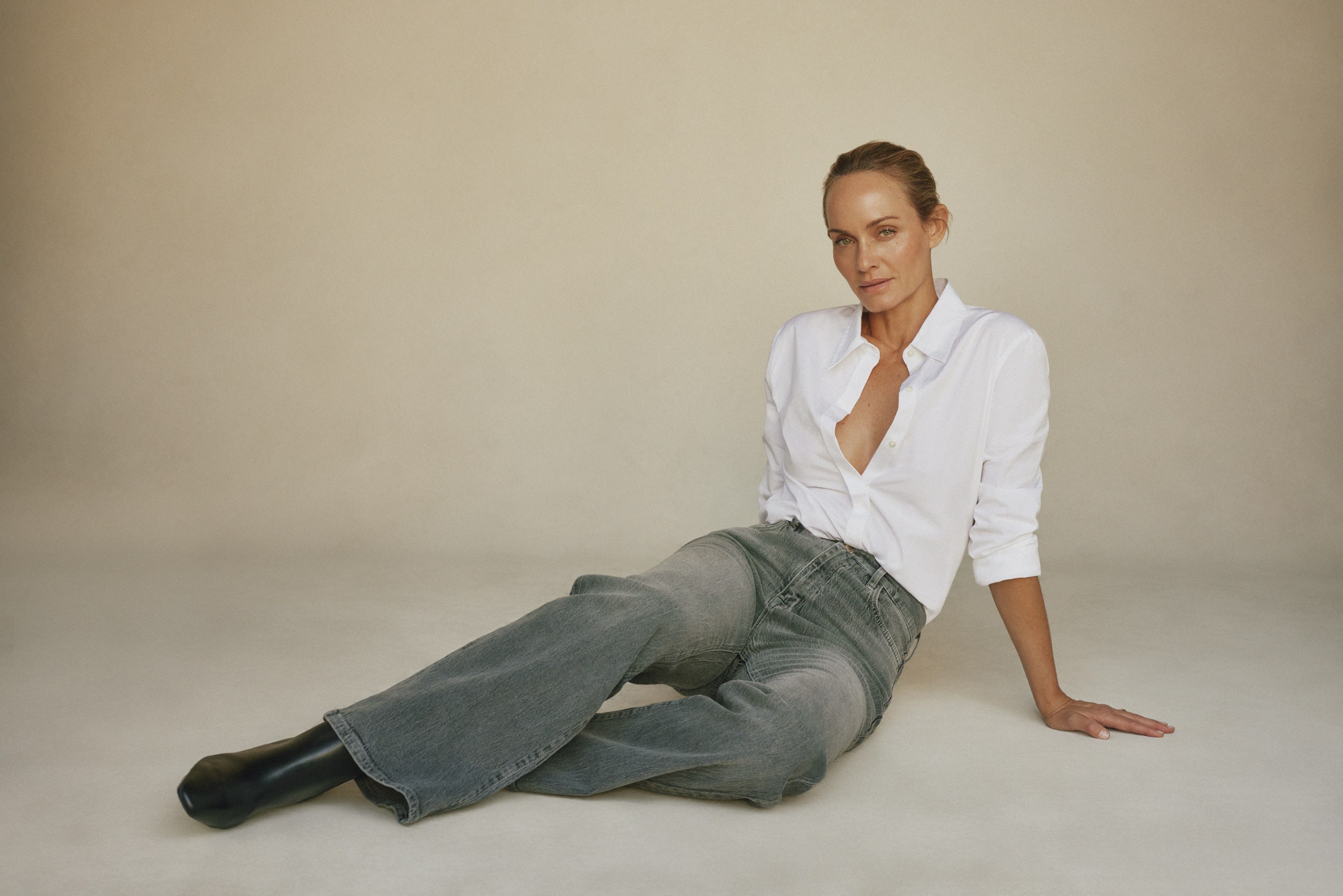 Image may contain Amber Valletta Clothing Pants Shirt Adult Person Sitting and Jeans