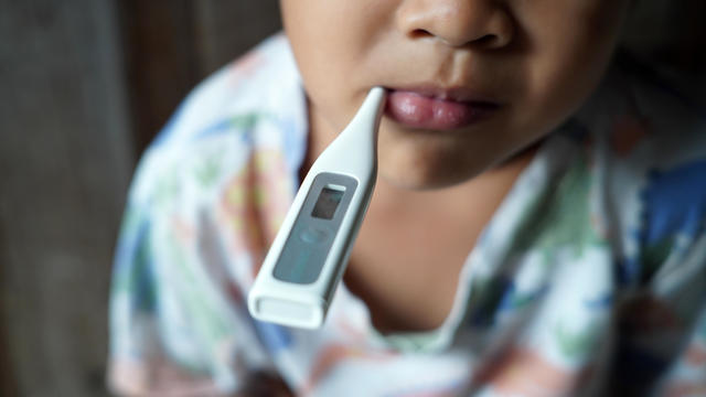 Sick little boy with a thermometer in his mouth 