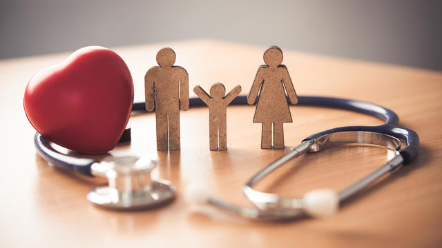 Medical Insurance Concept With Family  And Stethoscope On Wooden Desk 