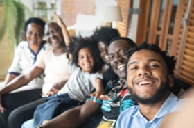 Group selfie of the smiling faces of six-member multi-generational family