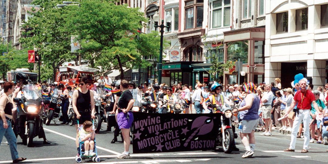 People during the 2001 Boston Pride Parade holding a banner that reads Moving Violations Motorcycle Club