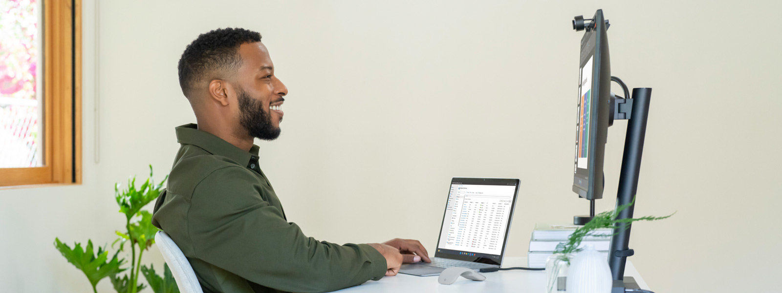 Man aan bureau met Surface-apparaat aangesloten op aparte monitor