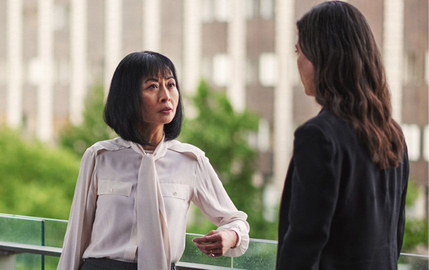 Two female workers having a discussion outside an office building.