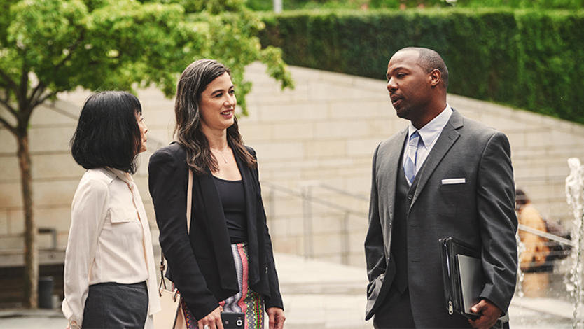 Three workers having a discussion outside city hall.