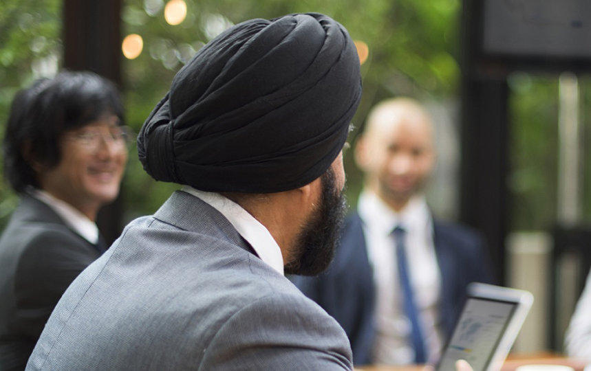 group of five business people sitting at a table for a meeting