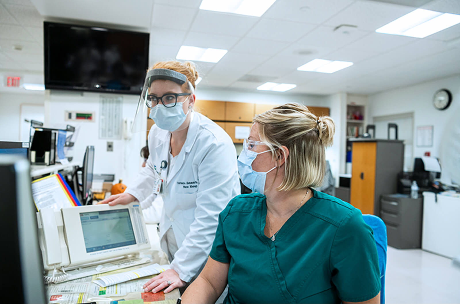 Masked medical professionals working at a desk