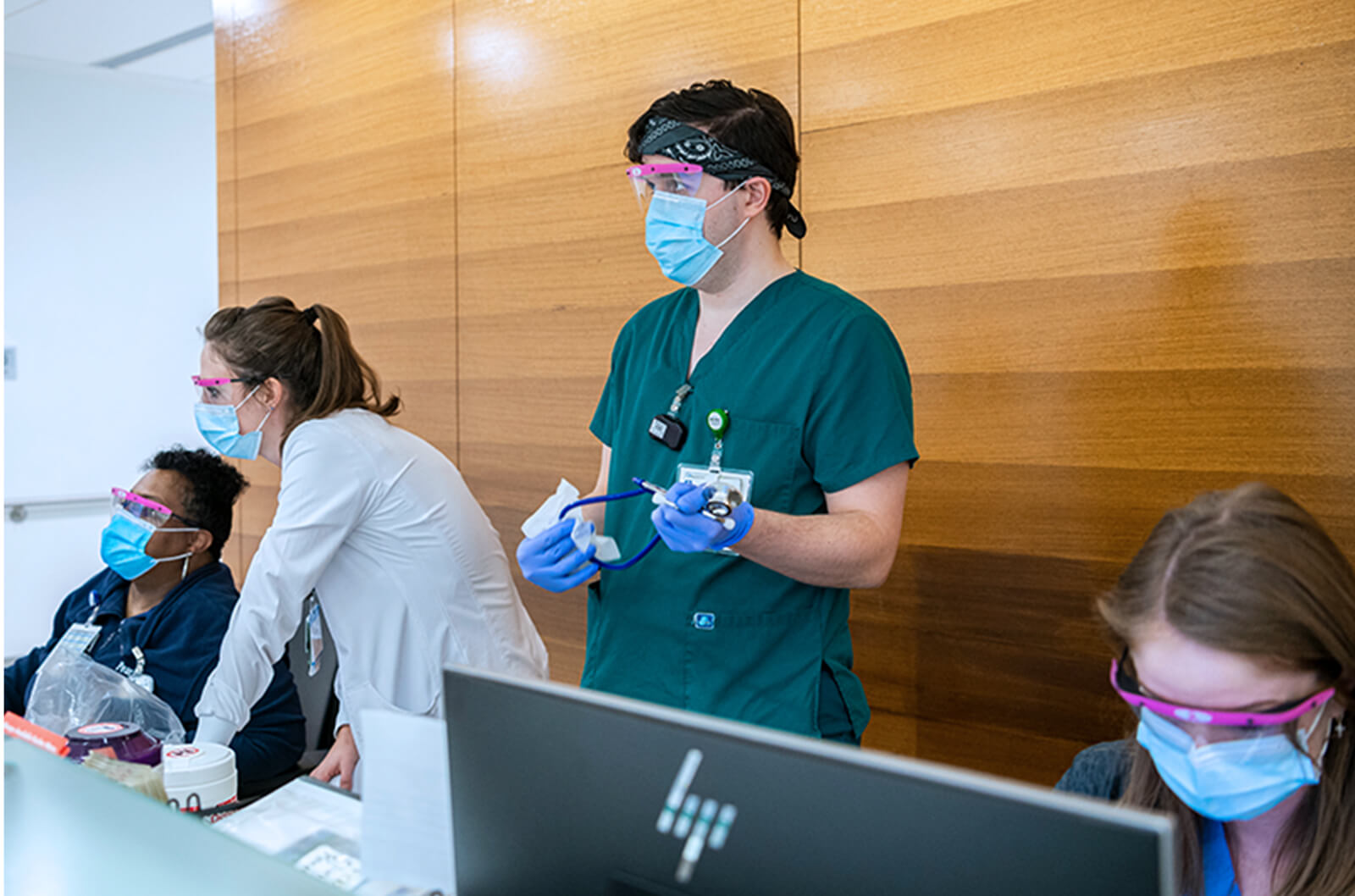 Masked medical professionals working at a desk