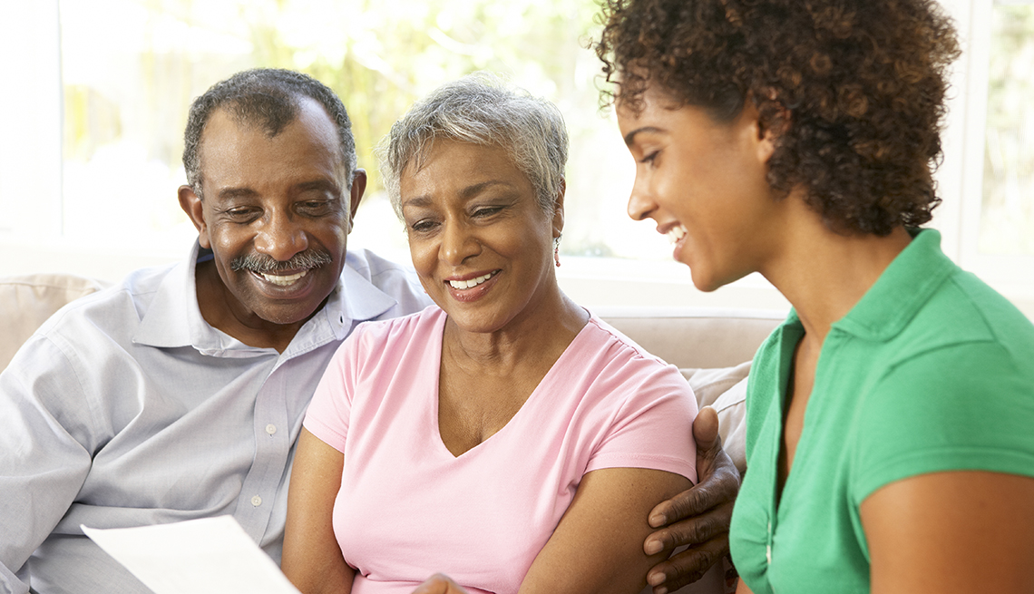 Adult daughter and parents reading through a caregiving guide