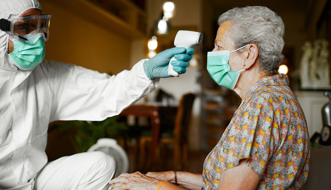 Man testing older woman for temperature