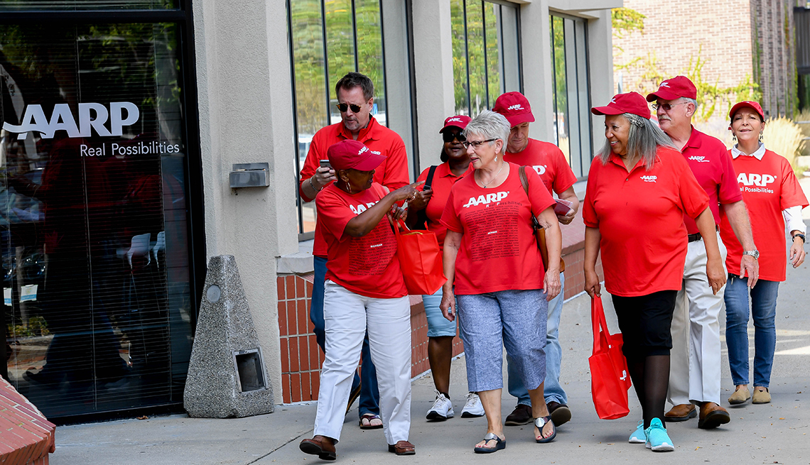 An group from an a a r p chapter walking down the street wearing red a a r p t shirts