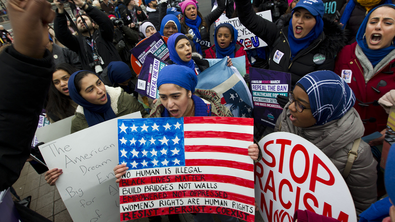 A group holds up signs at Freedom Plaza during the Women's March in Washington on Saturday, Jan. 19, 2019.