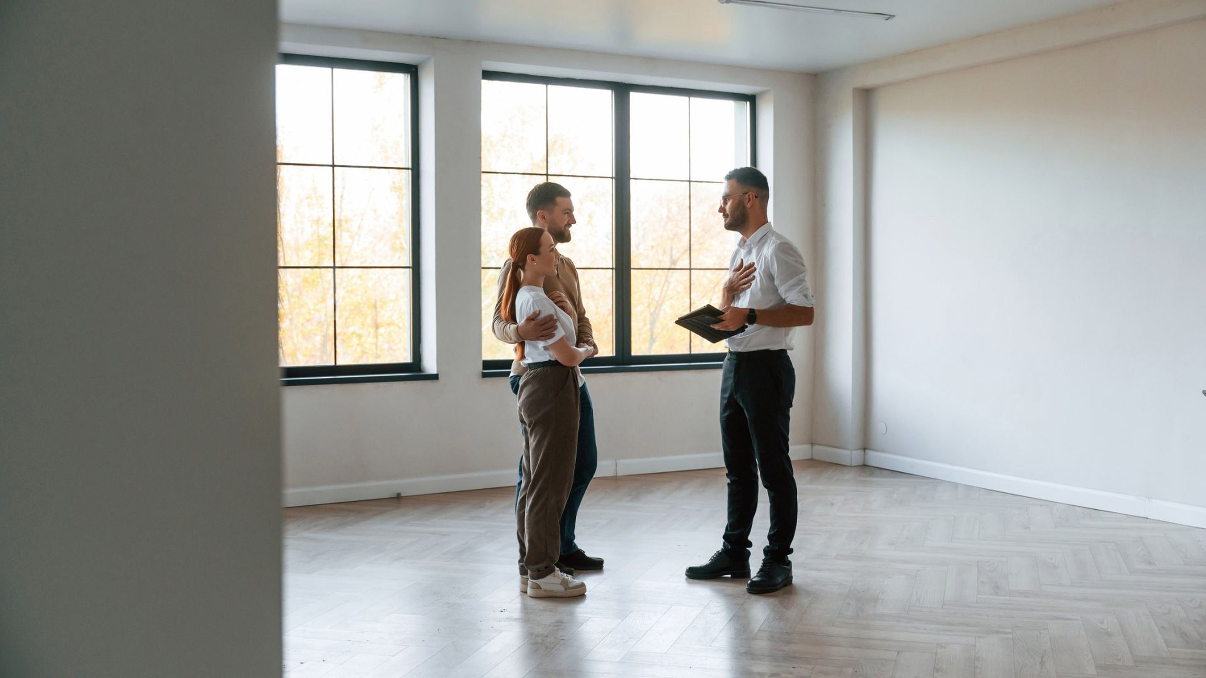 Una pareja visita un piso con un agente inmobiliario.