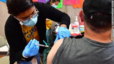 Registered Nurse Mariam Salaam administers the Pfizer booster shot at a Covid vaccination and testing site decorated for Cinco de Mayo at Ted Watkins Park in Los Angeles on May 5, 2022. - Covid cases in Los Angeles County have topped 3,000 for the first time since mid-February with cases up nearly 300 percent in the past month, sparking concern of a potential &quot;sixth wave&quot; pandemic in the US. 