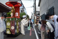 A Shinto priest is seen exorcizing evil spirits for people along the street during a shrine deity parade in Kyoto's Shimogyo Ward on July 19, 2021. (Mainichi/Yoko Minami)