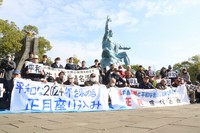 Participants in a sit-in hold up banners that read, "We demand a peaceful 2024" and other slogans in the city of Nagasaki on Jan. 1, 2024. (Mainichi/Mio Matsumoto)