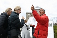 Kosei Mito, right, guides foreign visitors with a guidebook he created in his hand, in Hiroshima's Naka Ward on Feb. 4, 2024. (Mainichi/Noboru Ujo) 