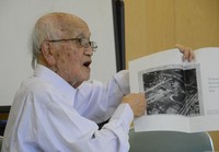 Nagasaki A-bomb survivor Shohei Tsuiki holds up a photo of his devastated city burned and blackened by the nuclear explosion as he speaks about his experiences in the city of Nagasaki on Nov. 2, 2024. (Mainichi/Arina Ogata)