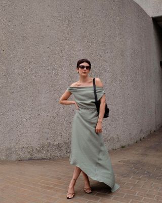 Woman wearing a long green dress and belt.