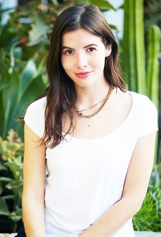 a close-up photo of an editor wearing a white t-shirt and jeans with an underwire bra