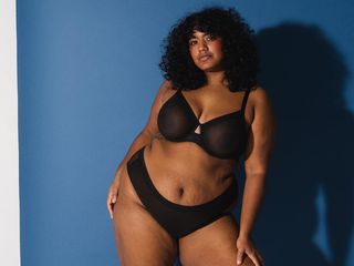 Weronica wears a black bra with matching underwear with a deep blue background.