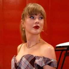 Taylor Swift arrives at the Chiefs game wearing a Vivienne Westwood set with a gold choker glitter freckles and red lipstick