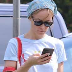 Olivia Wilde at a sports match for her child wearing a white T-shirt, jeans, a bandana, and Onitsuka Tiger's new Mexico 66 Sabot slides.