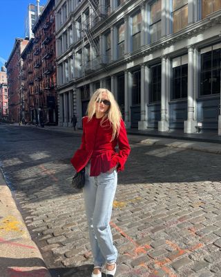 Eliza Huber wearing a red velvet jacket with classic vintage Levi's 501 jeans and black-and-white Chanel Mary Jane flats.