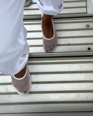 Woman wearing white mesh flats.