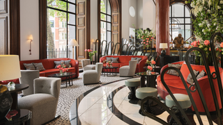 The Lobby Bar at One Aldwych, with big windows, red velvet seating and a black and white marble floor