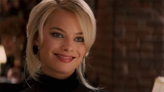 Margot Robbie smiles at Leonardo DiCaprio at dinner in The Wolf of Wall Street