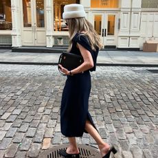  @elizagracehuber wearing an ivory pillbox hat with a navy dress, and Saint Laurent black Manhattan bag on the streets of SoHo in NYC.