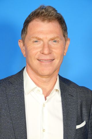 a photo of bobby flay wearing a grey suit and smiling