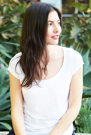 a close-up photo of an editor wearing a white t-shirt and jeans with a no-show bra