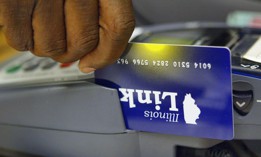 An Illinois Department of Human Services office clerk demonstrates the activation of an Illinois Link card. The federal reimbursements available for such cards that have been skimmed and had benefits stolen could end Dec. 20 without legislation to extend the program.