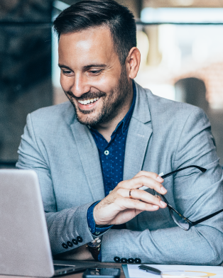 Man smiling while working on computer