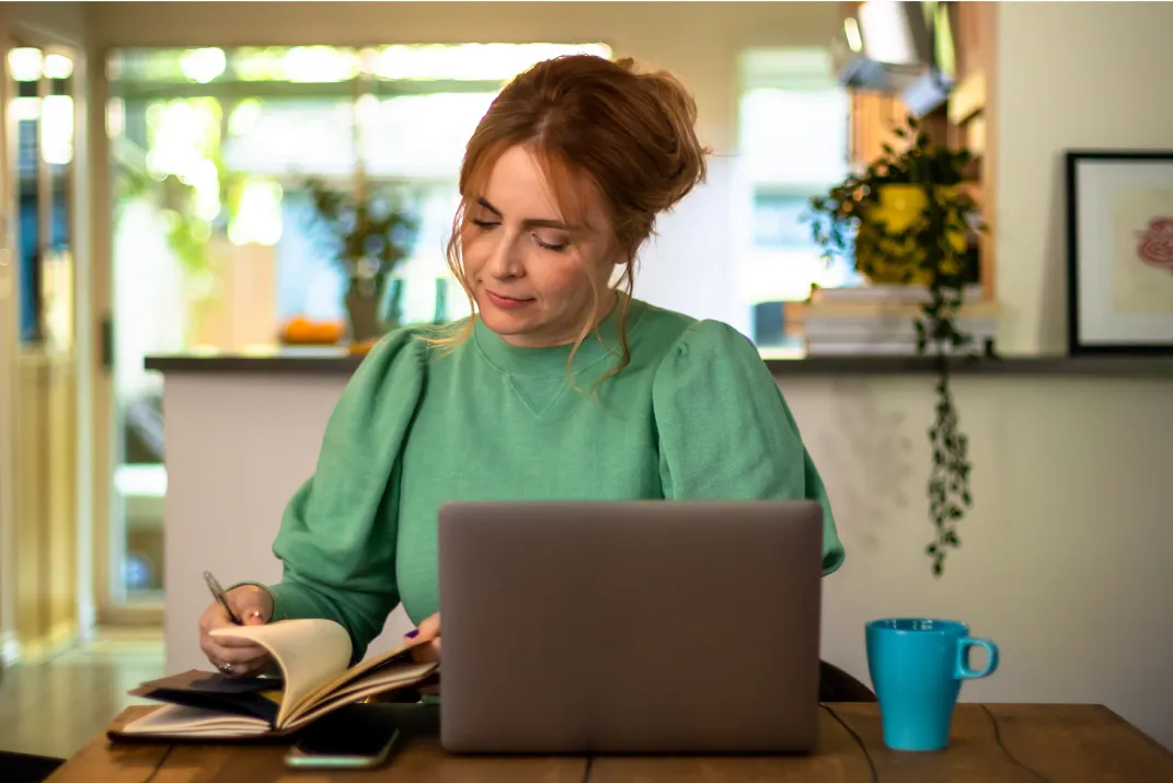 A Tucows employee works in a brightly lit area at a large window table