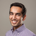 A man in a purple shirt smiling