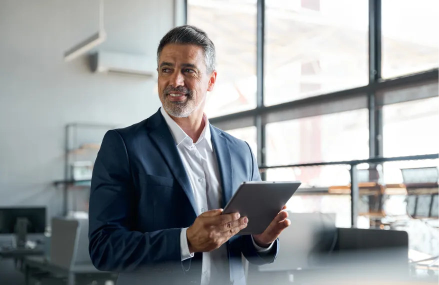 A man in a suit holding a tablet.