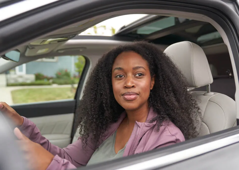 A female driver sitting in a car's driving seat