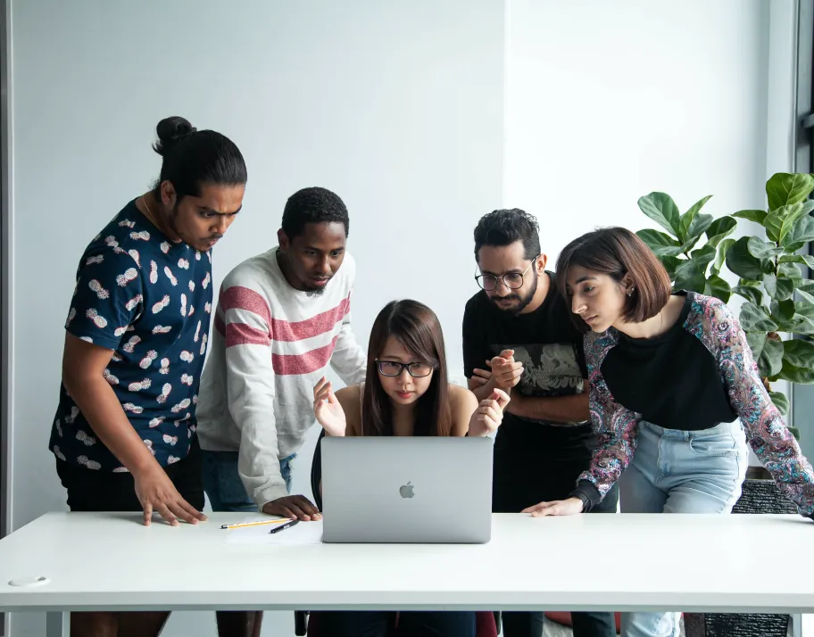 Deriv employees discussing ideas on a laptop