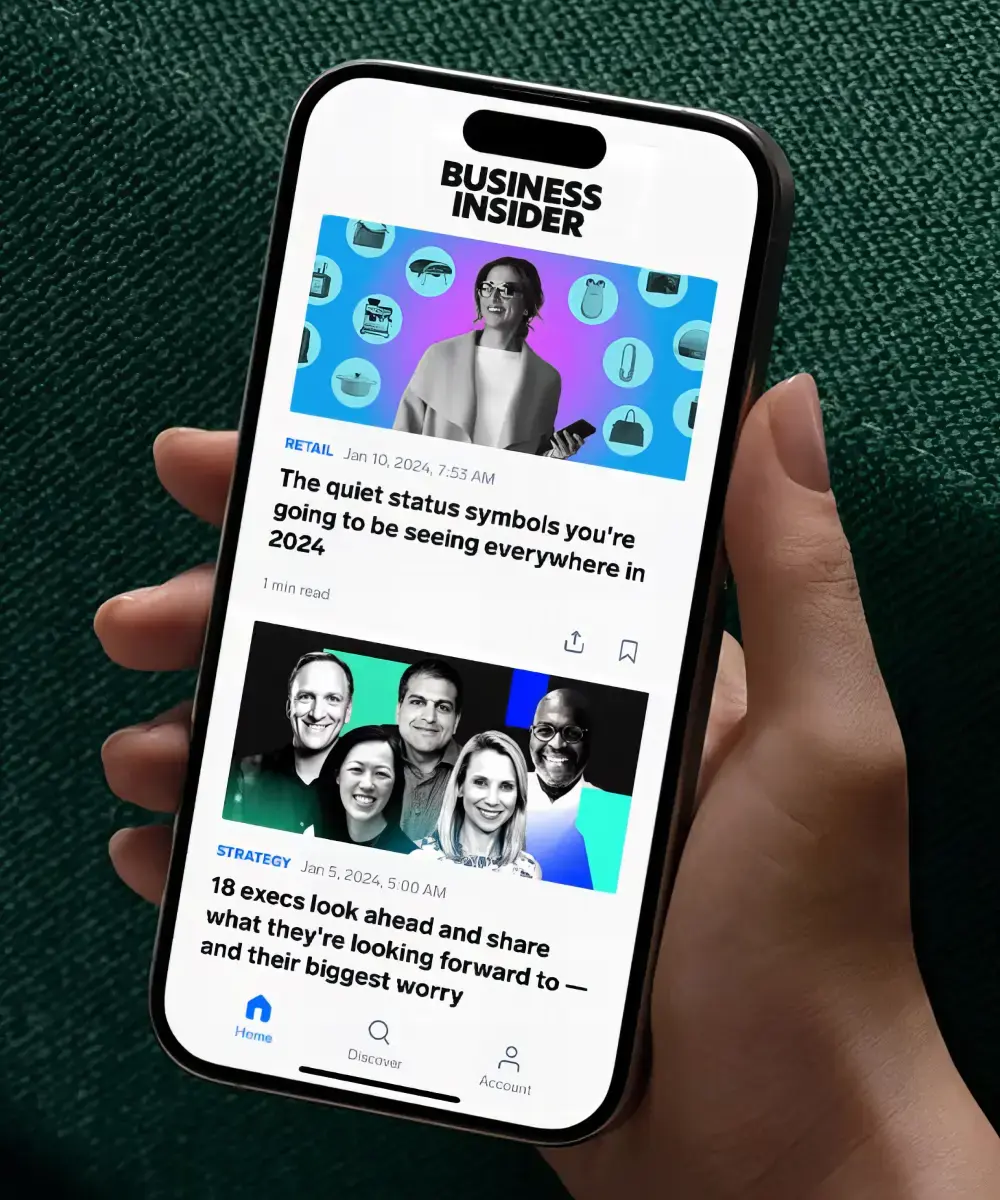 Someone holding an phone displayed with the Business Insider app.